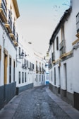Quiet cobblestone street lined with whitewashed buildings near Jaén's old town.