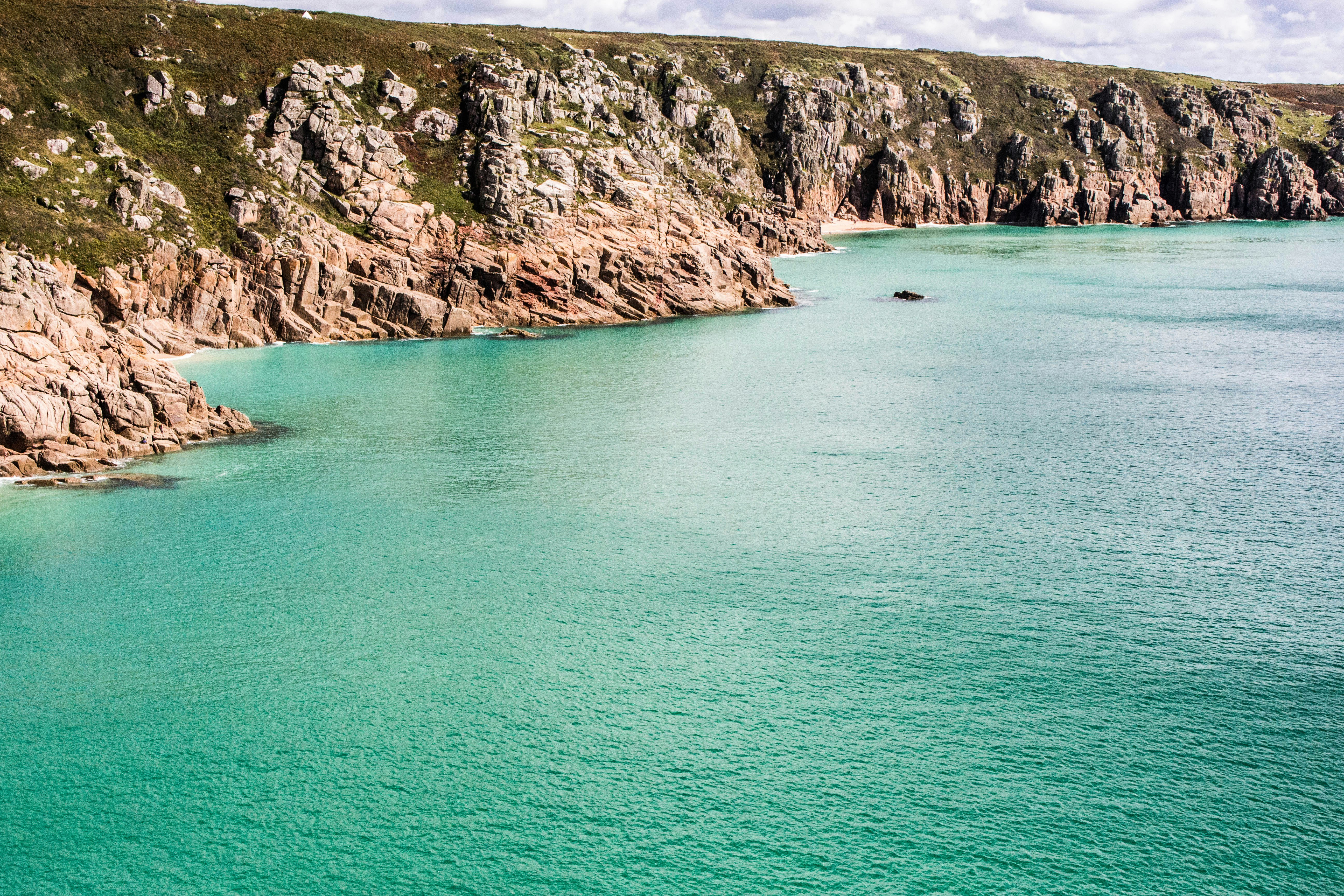 wide angle photo of cliff near body of water