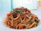 Close-up of a steaming bowl of pasta with fresh basil garnish