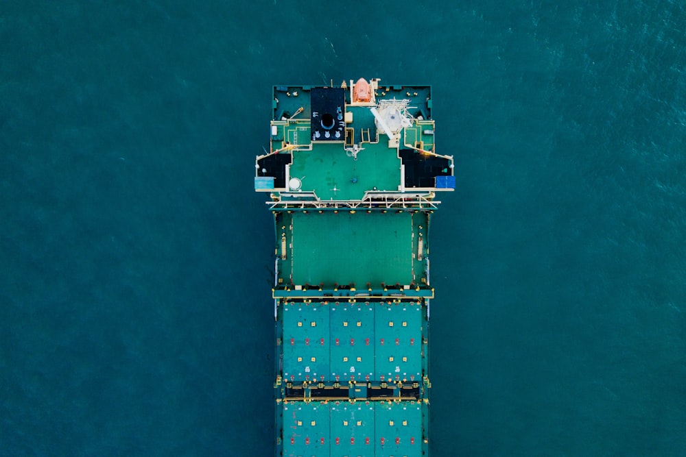 green cargo ship on body of water