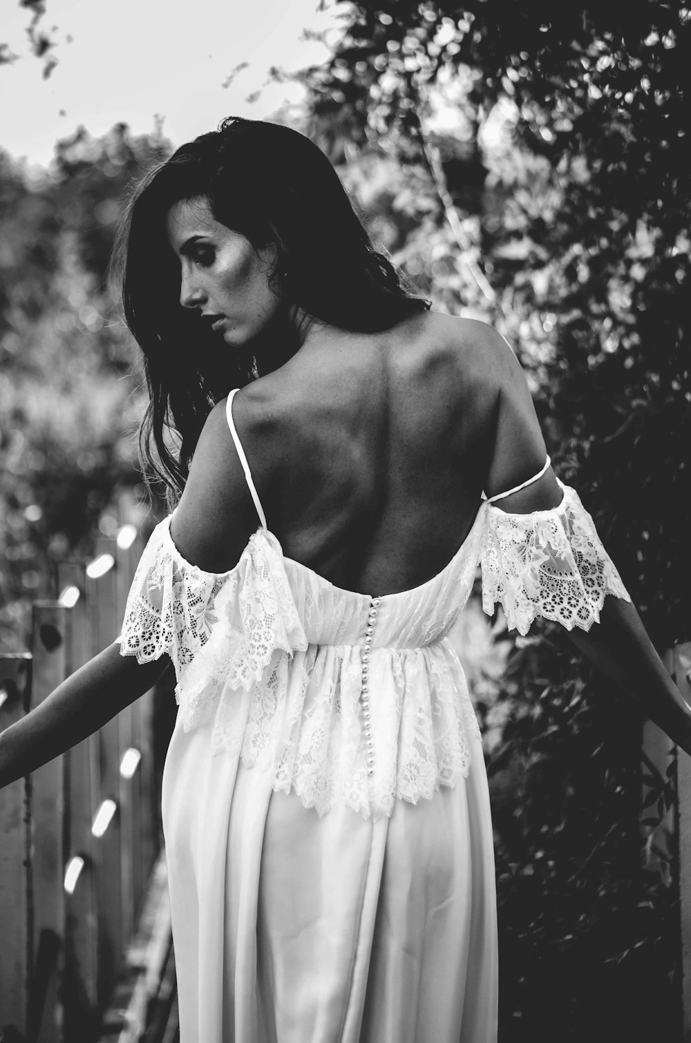 grayscale photo of woman wearing cold-shoulder backless dress