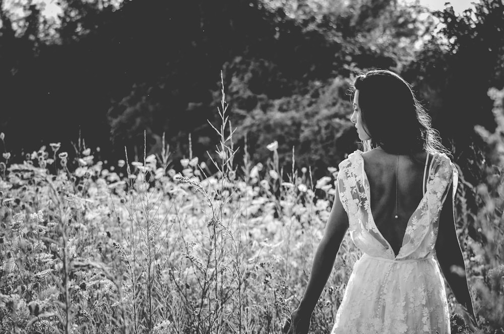 Fotografía en escala de grises de mujer con vestido de novia sin espalda