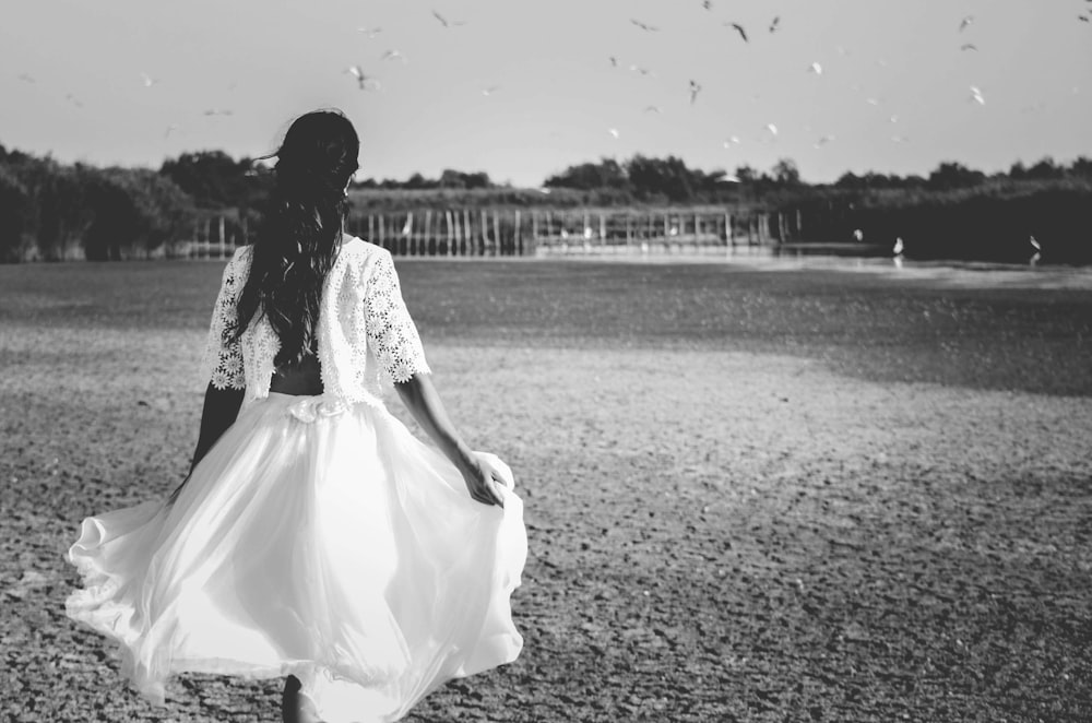 grayscale photo of woman on grass field