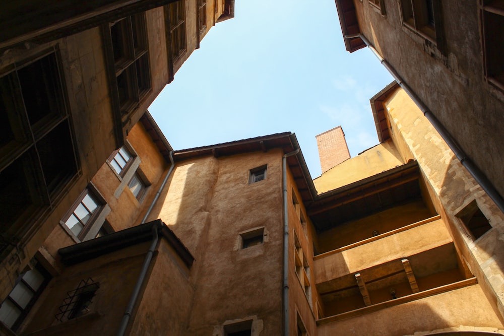 low angle photo of brown concrete building under blue sky during daytime