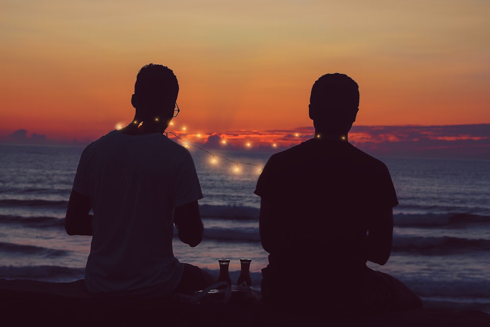 Silhouette eines Mannes, der während des Sonnenuntergangs am Strand steht