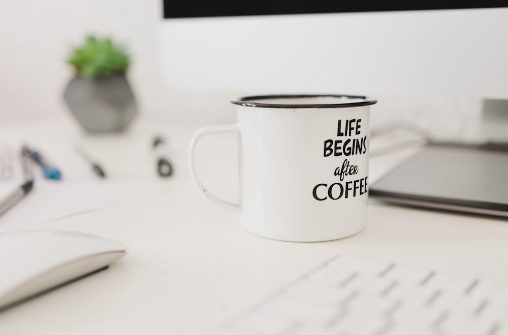 selective focus photo of white mug near wireless mouse