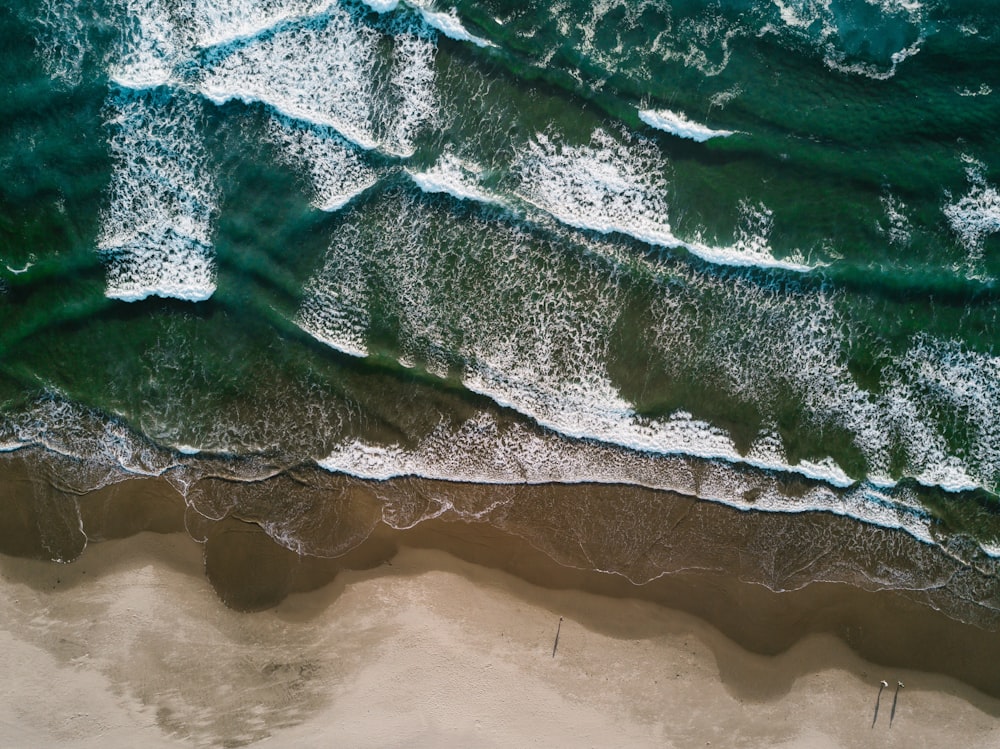 Fotografía aérea de las olas del mar cerca de la orilla del mar durante el día