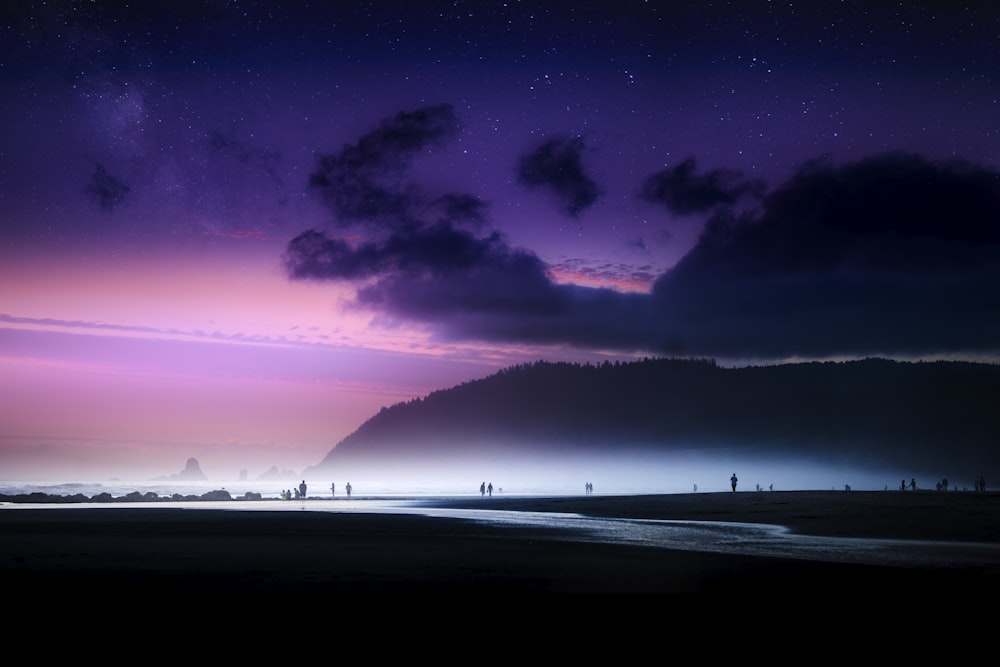 silhouette of people standing near mountain