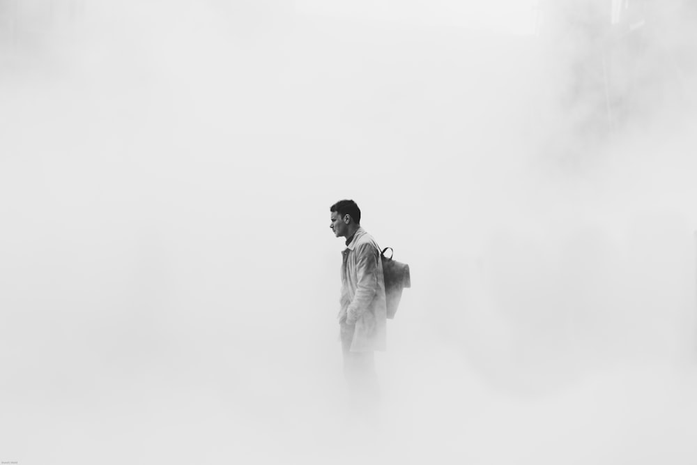 grayscale photo of man surrounded by fogs