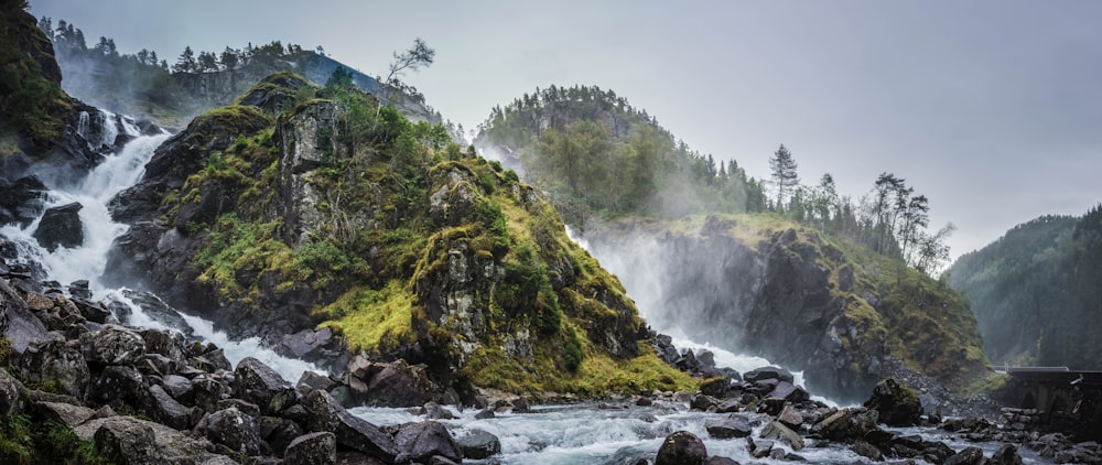 waterfalls between two green mountains