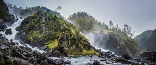 waterfalls between two green mountains in Låtefossen Waterfall Norway