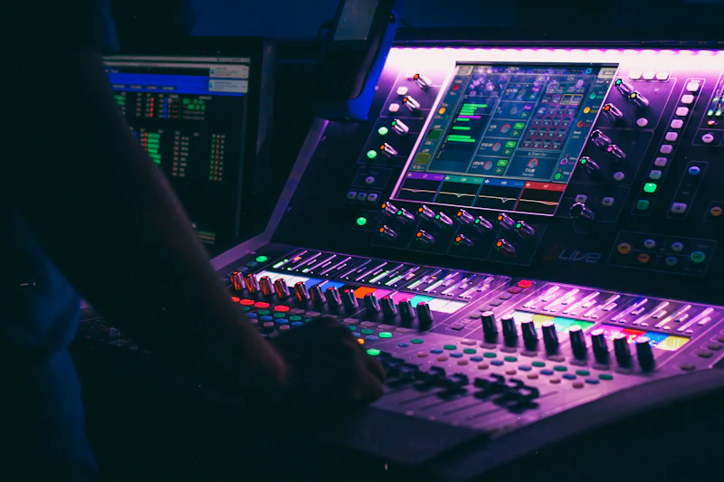Sound engineer adjusting levels behind the glass in a control room