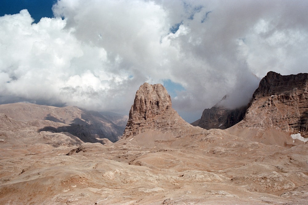 brown rock formation under white clouds at daytime