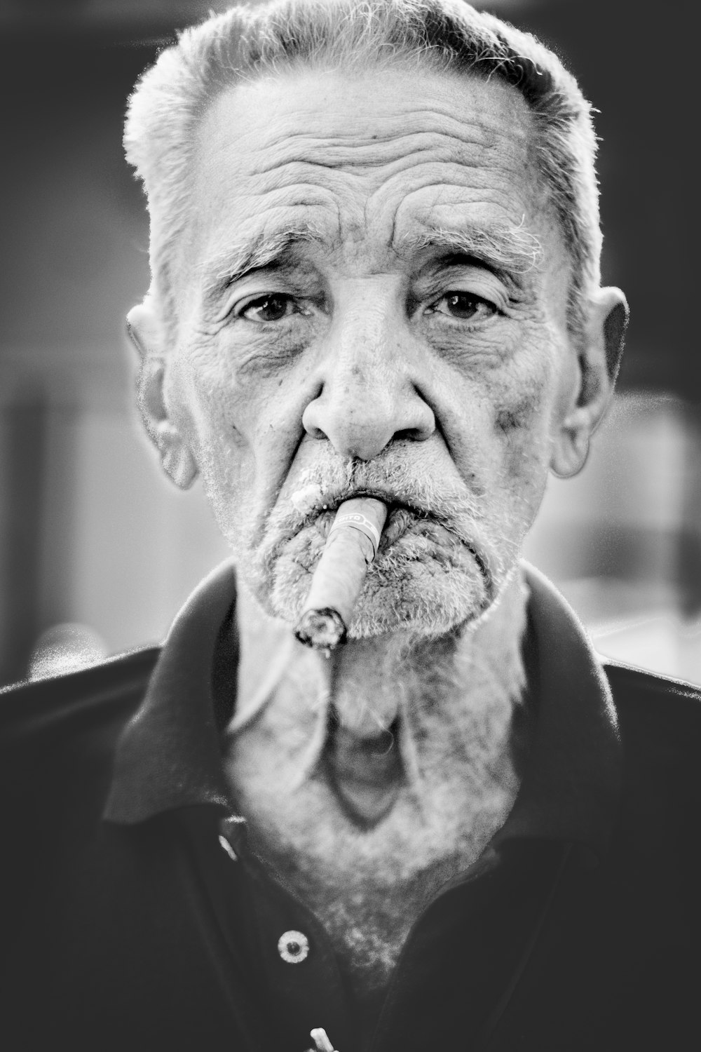 Photographie en niveaux de gris d’un homme fumant un cigare