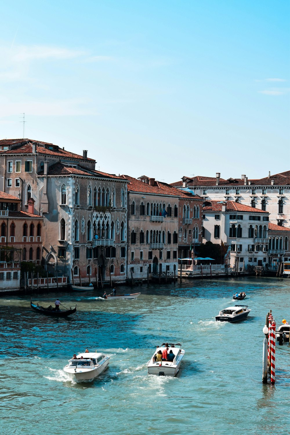 people riding boat near buildings during daytime