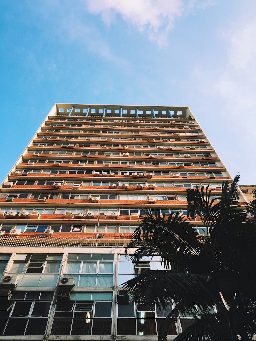 Edificio de gran altura pintado de naranja y blanco