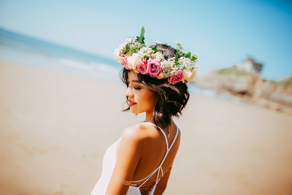 woman wearing white halter dress and floral tiara at shore during daytime