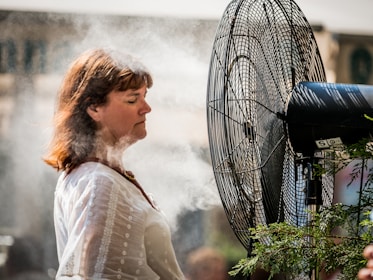 Close-up of a portable misting fan keeping a traveler cool on a hot day.