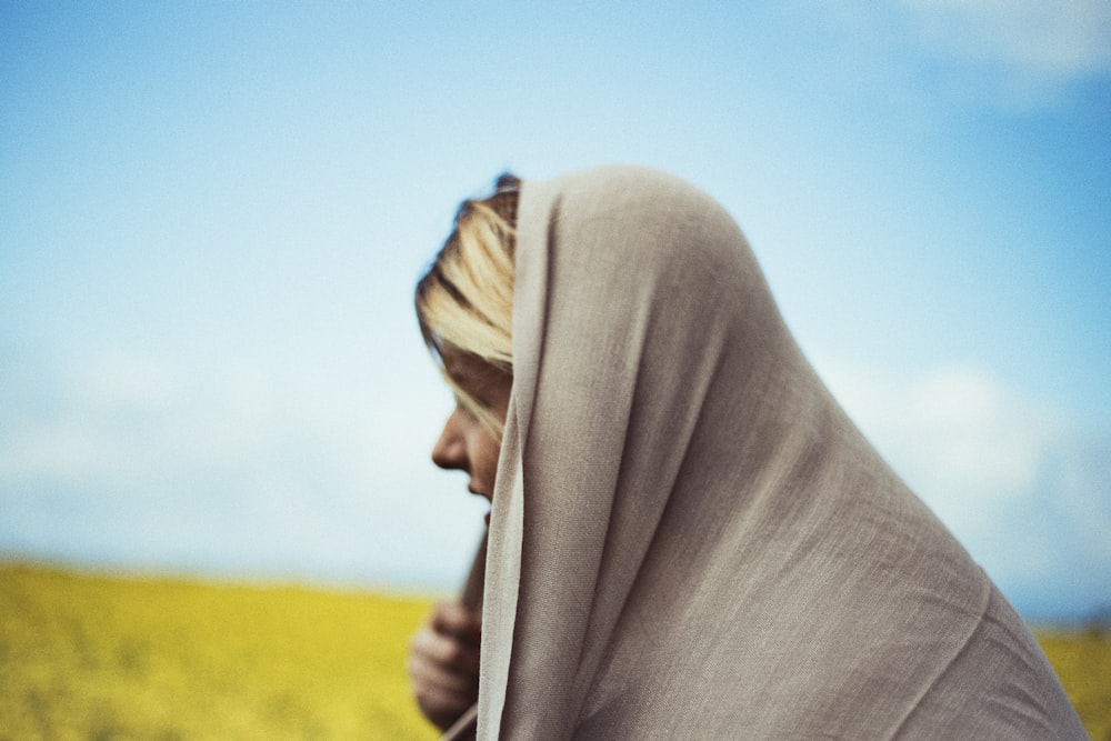 Frau mit grauem Kopfschmuck auf Wiese in der Modefotografie