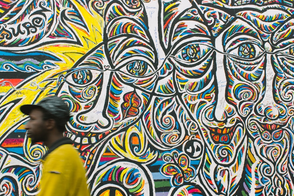 man standing near graffiti art