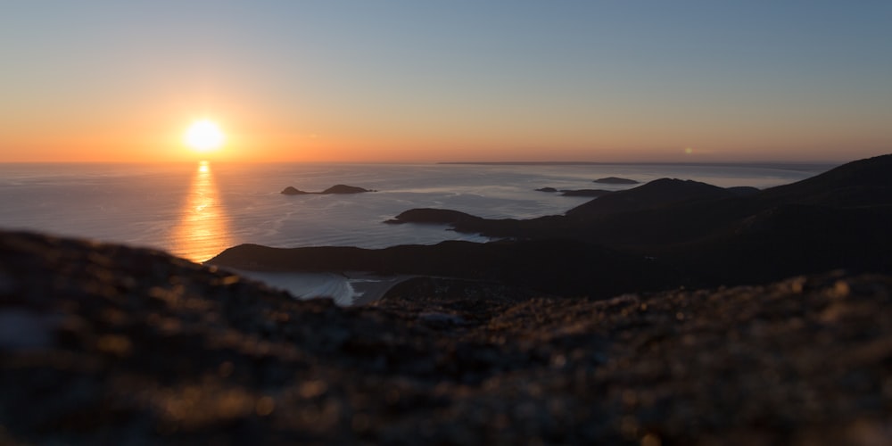 formazione rocciosa vicino al mare sotto il cielo blu e bianco durante la fotografia al tramonto