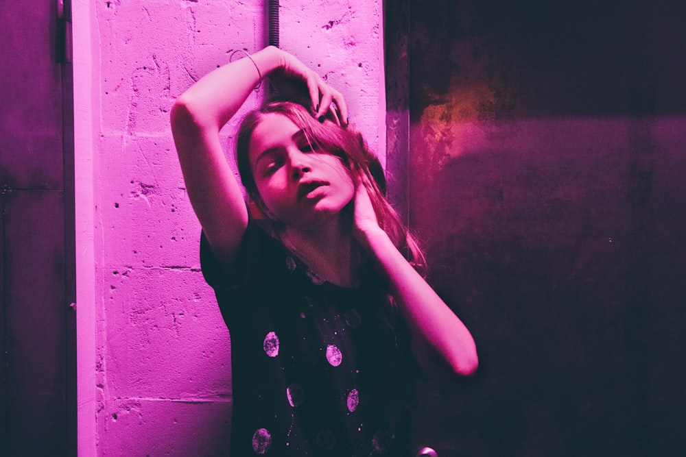 photo of woman posing near wall