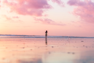 woman standing on seashore in front of body of water