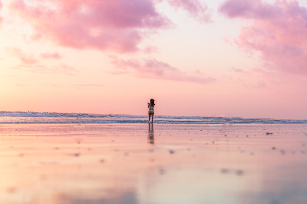 donna in piedi sulla riva del mare davanti allo specchio d'acqua