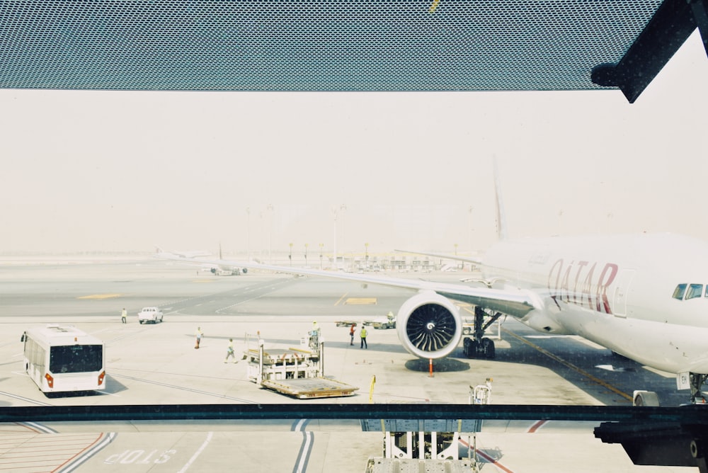 낮 동안 공항에 흰색 카타르 비행기