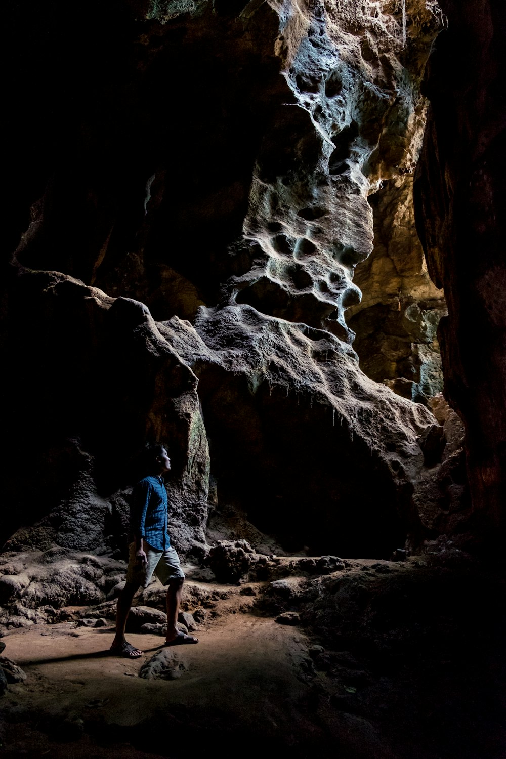 Homem na camisa azul dentro da caverna