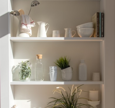 bowls and bottles in white wooden 4-layer shelf