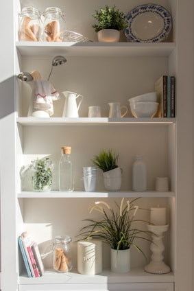 A neatly arranged kitchen shelf featuring sholab llc's compact, stylish storage boxes blending into a cozy home setting.