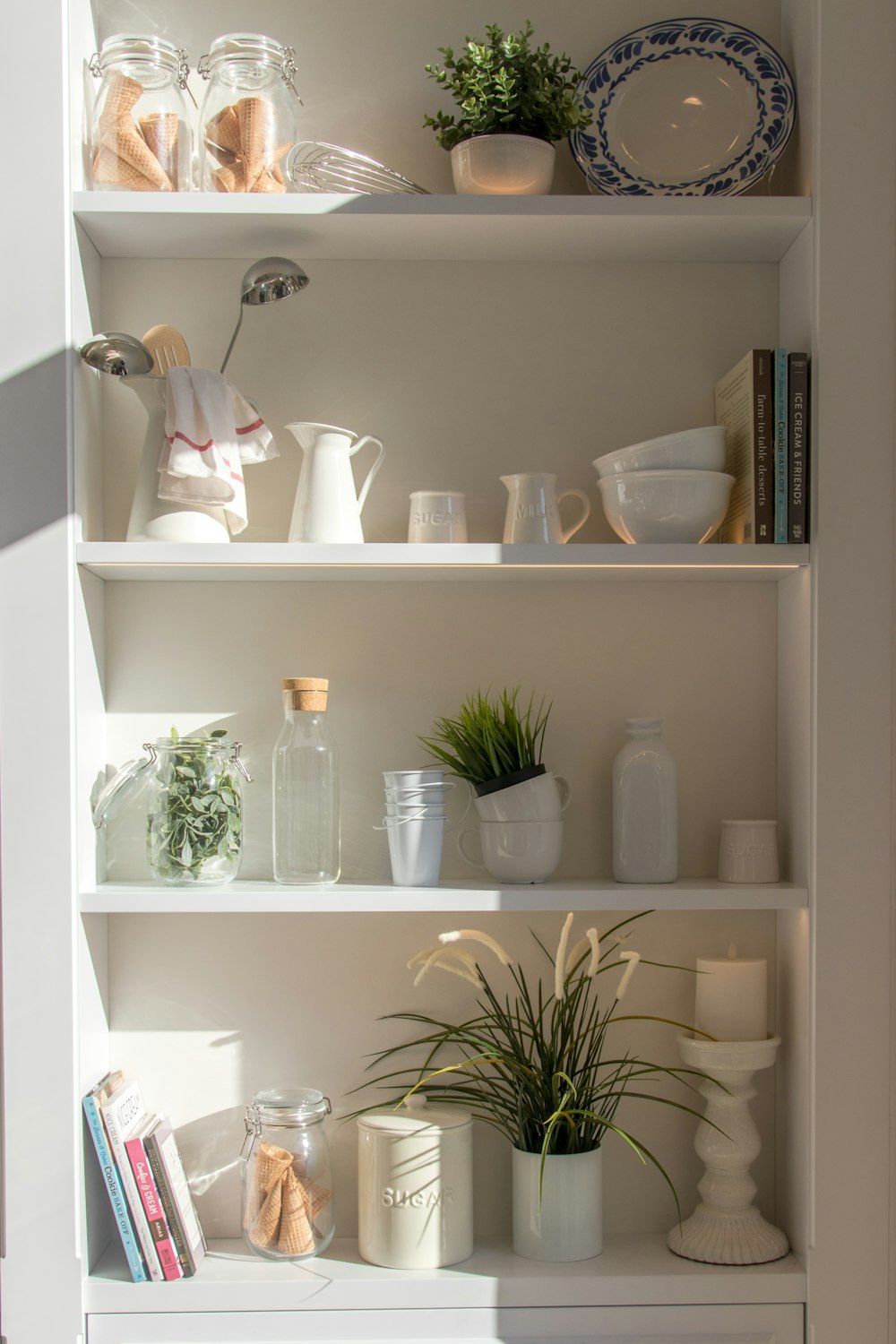 bowls and bottles in white wooden 4-layer shelf