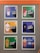 A display of six framed posters on a grey wall featuring various graphic designs and text related to milkshakes. Each poster has a colorful background and an illustration resembling a character with words like 'I just love the science of shakes,' 'sexy shakes,' and 'thickshake? oh yeah.' The posters have a humorous and playful design with vibrant characters.