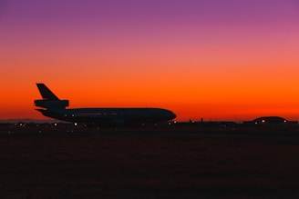 A sleek airplane touching down on a runway at sunset, symbolizing global cargo delivery.