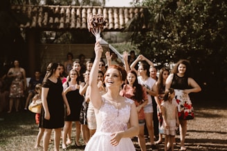 bride throwing flower bouquet on women during daytime