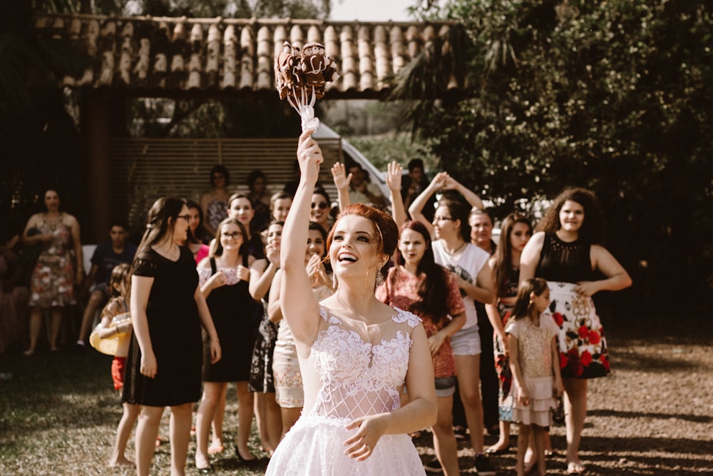 novia arrojando ramo de flores a las mujeres durante el día