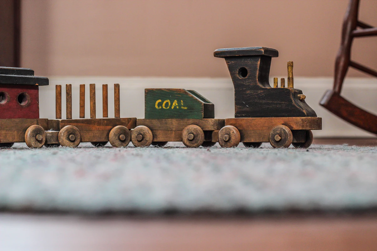 A beige wooden toy train with rounded edges resting on a wooden floor