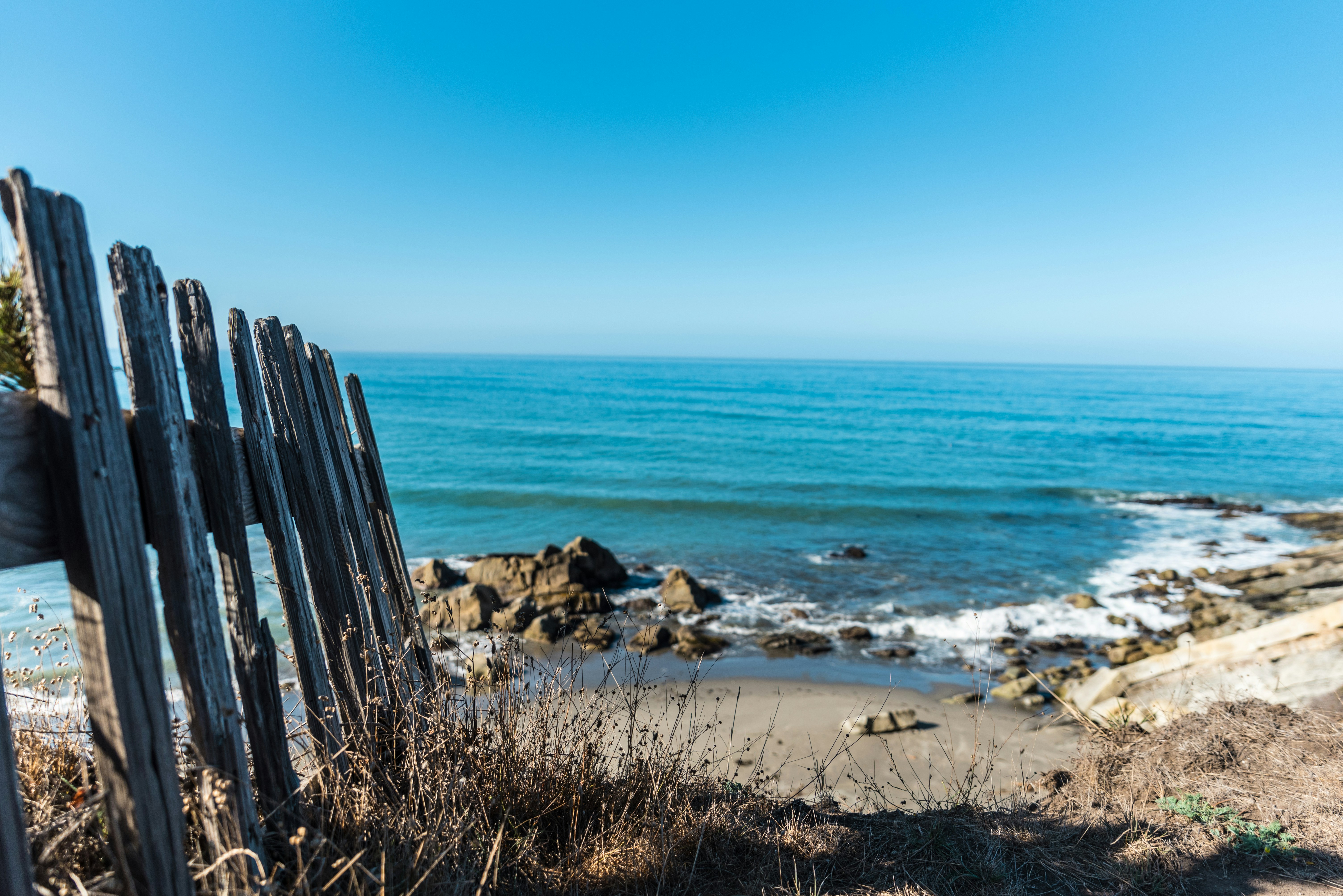 brown wooden fence near shore during daytime