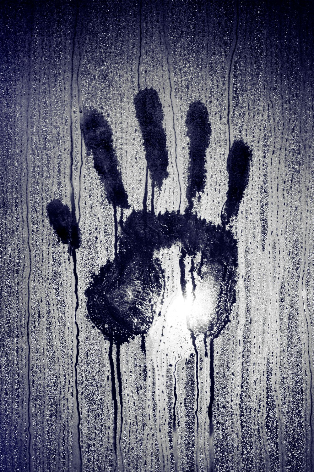 person's hand print on moistened glass