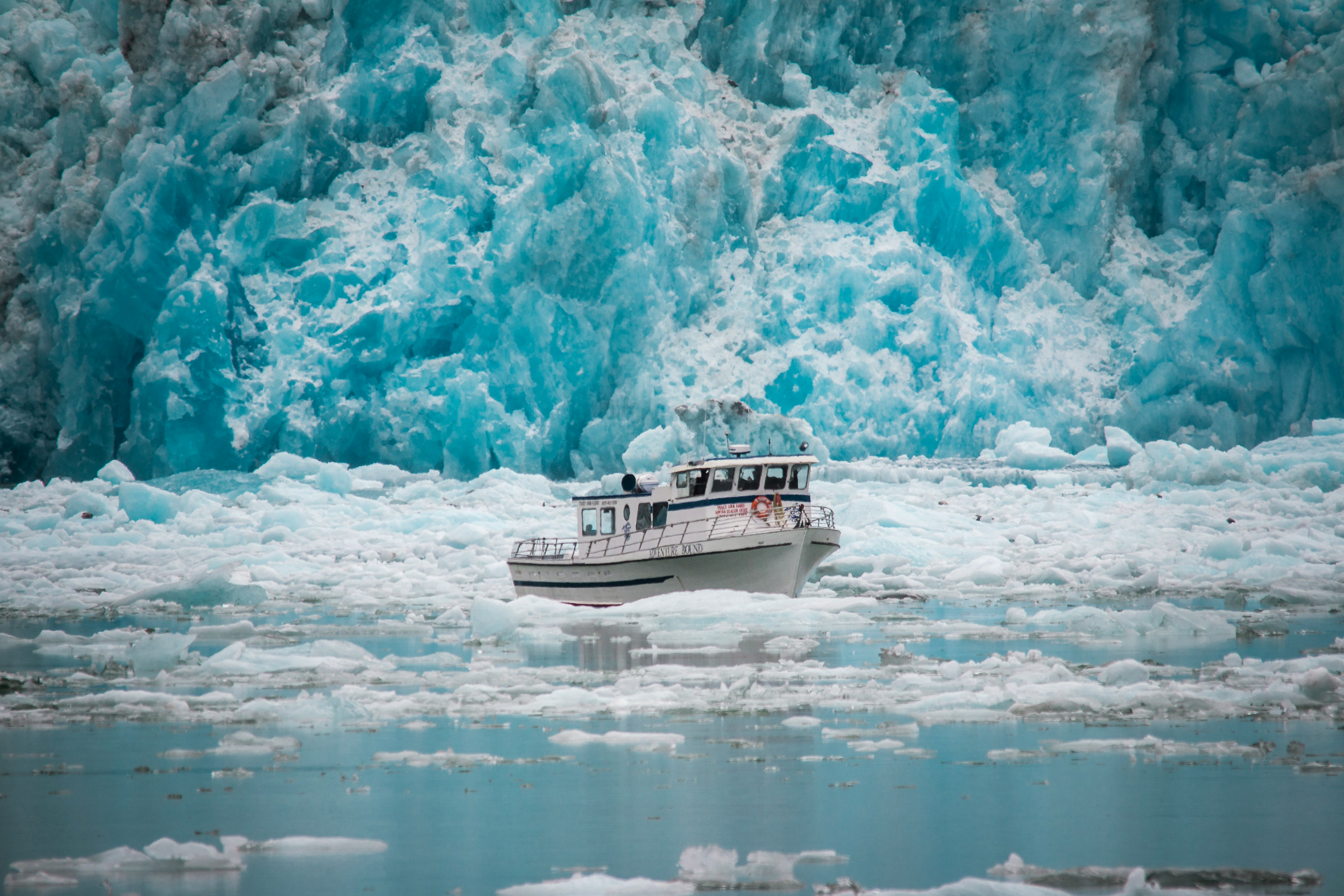 white boat surrounded by floating ice
