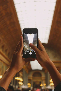 Person taking a photo of an interior corner with a smartphone.