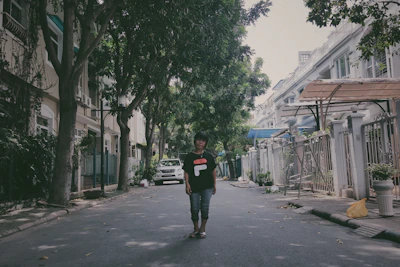 Joshua walking through a quiet Chicago neighborhood street lined with trees and classic Midwestern homes.