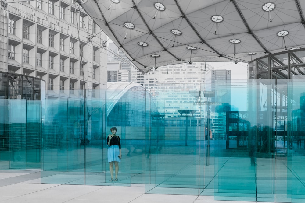 woman standing behind clear glass wall during daytime