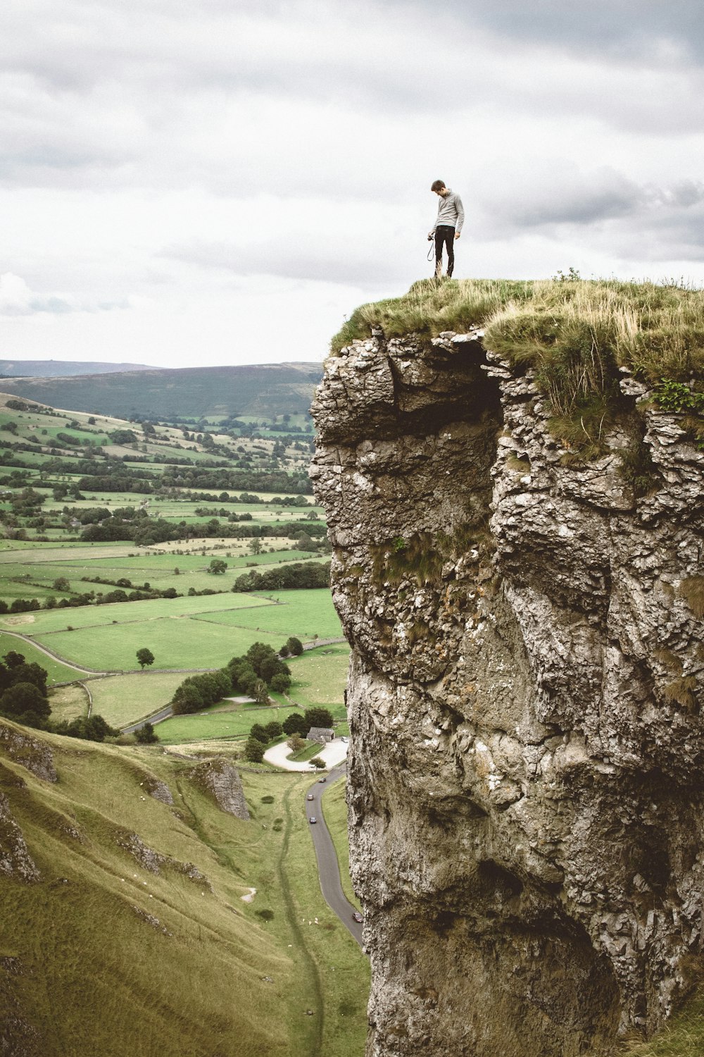 man standing on the edge of cliff taken at daytime