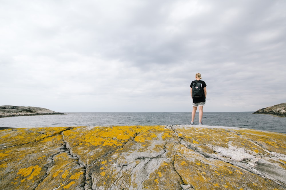 woman standing near body of water during daytime