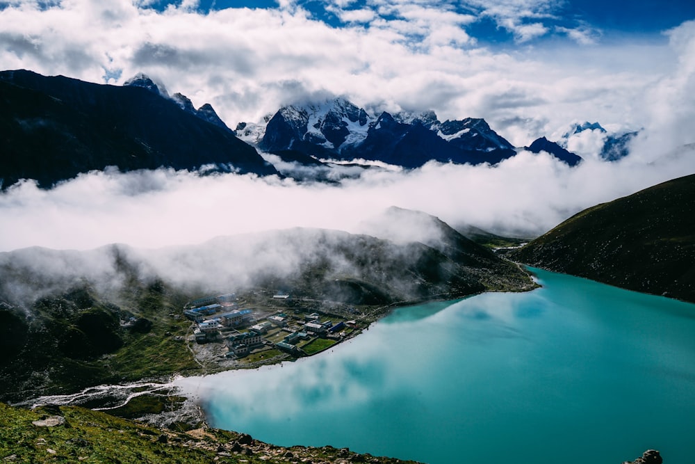 calm lake on green tree-covered mountains under cloudy skies