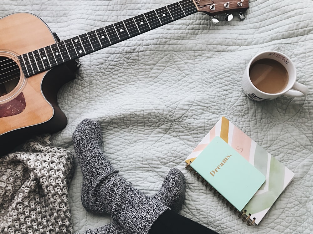 person wearing gray socks near acoustic guitar