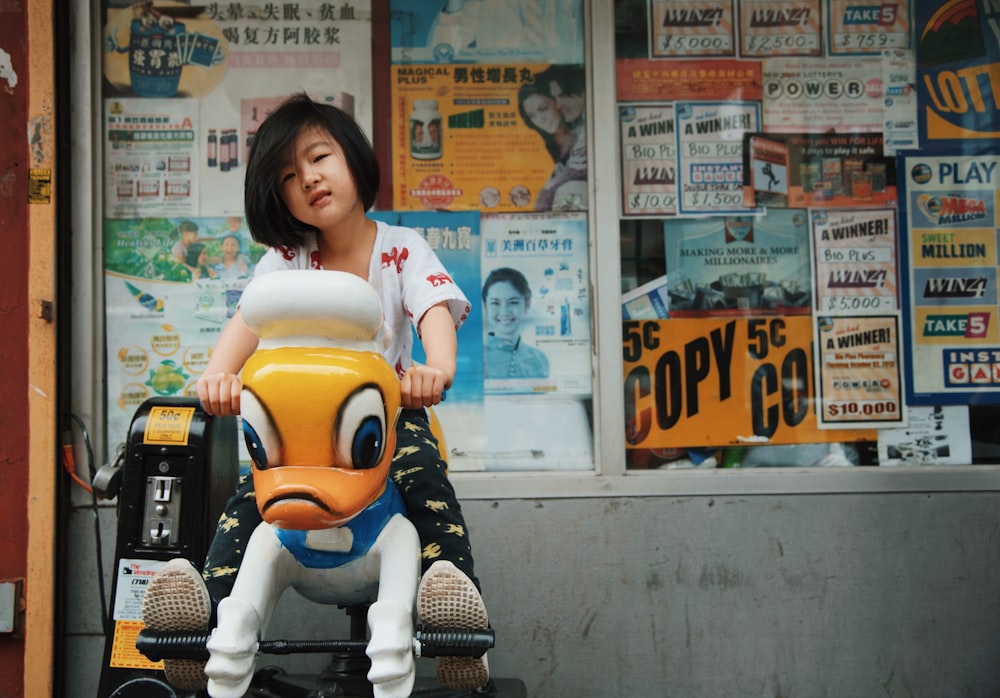 girl riding a Donald Duck arcade