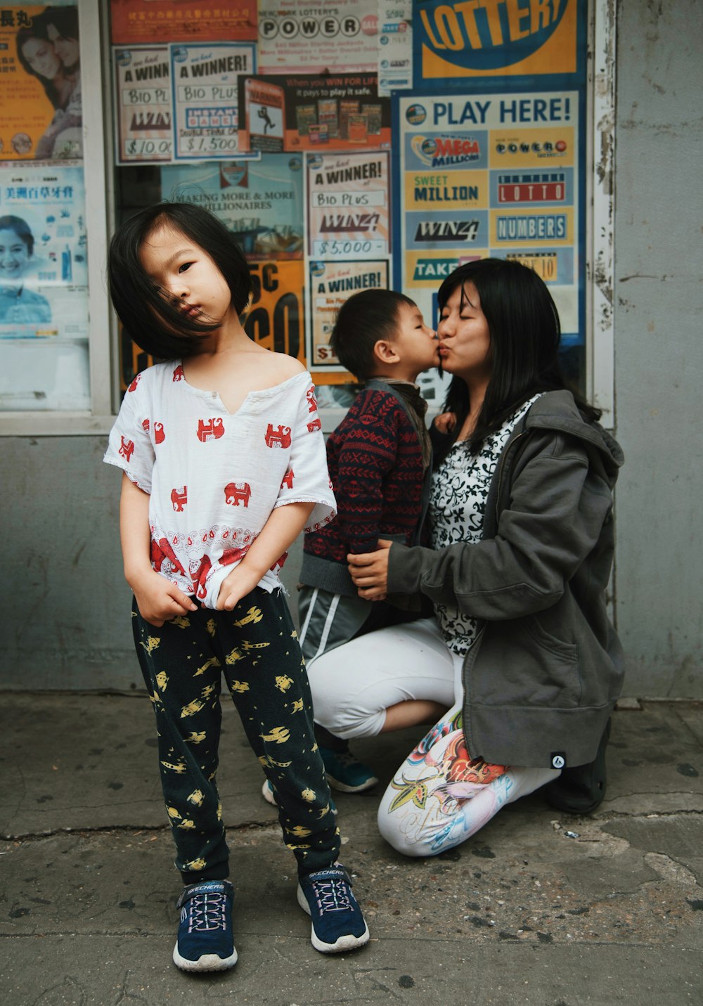 woman kissing boy near girl taking selfie